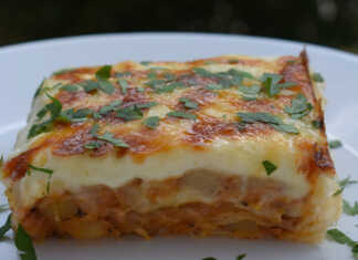 Ένα λαχταριστό ταψί με μουσάκα που έχει στρώσεις από φύλλα πίτας και ροδισμένη μπεσαμέλ με λιωμένο τυρί