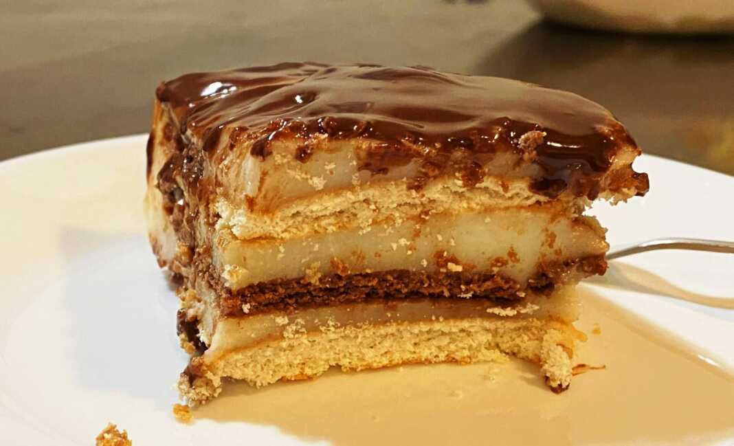 Κομμάτι από μπισκοτογλυκό με σοκολάτα και μπανάνα, που δείχνει τις στρώσεις μπισκότων, κρέμας και μπανάνας