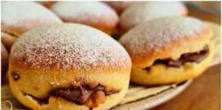 Αφράτα ντόνατς γεμιστά με σοκολάτα, πασπαλισμένα με άχνη ζάχαρη σε πιατέλα.