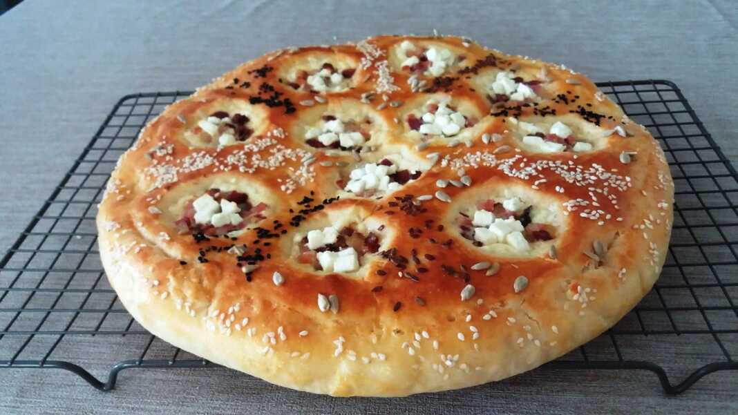 Το ψημένο **Αφράτο Ζαμπονοτυρόψωμο** στο ταψί, πασπαλισμένο με σουσάμι και ηλιόσπορους.