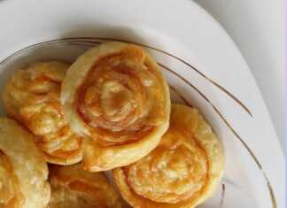 Ζαμπονοτυροπιτάκια σε πιατέλα, φρεσκοψημένα, με χρυσαφένια σφολιάτα και το λιωμένο τυρί να φαίνεται στο εσωτερικό.