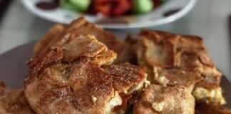 Κοντινό πλάνο σε ένα κομμάτι από Κολοκυθόπιτα με Χειροποίητο Φύλλο, που αναδεικνύει τις στρώσεις του φύλλου και την πλούσια γέμιση.