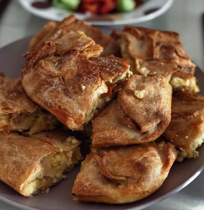 Kolokithopita Κοντινό πλάνο σε ένα κομμάτι από Κολοκυθόπιτα με Χειροποίητο Φύλλο, που αναδεικνύει τις στρώσεις του φύλλου και την πλούσια γέμιση.