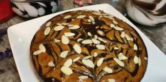 Αφράτο κέικ ζέβρα κομμένο σε φέτες με εντυπωσιακά σχέδια σοκολάτας και βανίλιας πασπαλισμένο με φιλέ αμυγδάλου