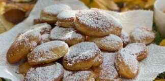 Αφράτες τηγανίτες, πασπαλισμένες με άχνη ζάχαρη, σερβιρισμένες σε στοίβα με φράουλες.