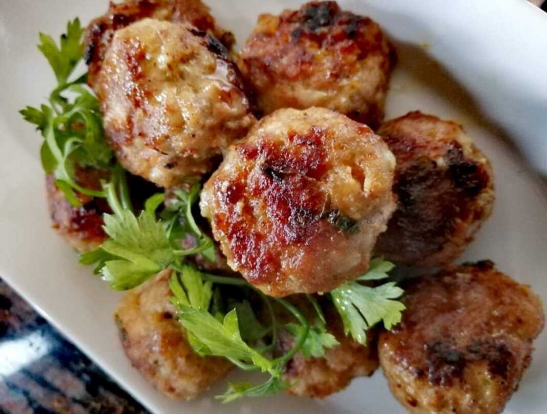 Ζεστοί, ροδοψημένοι μοσχαρίσιοι κεφτέδες σε ένα τηγάνι, περιχυμένοι με μια χρυσαφένια σάλτσα λεμονιού.