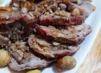 Ψημένο αρνίσιο μπούτι-ρολό, τυλιγμένο με φέτες μπέικον και δεμένο με σπάγκο, με κάστανα και αρωματικά γύρω του, μέσα σε πιατελα