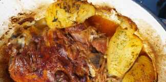 Ένα ολόκληρο κομμάτι αρνί στο φούρνο με πατάτες, ψημένο και ροδισμένο, μέσα σε ταψί