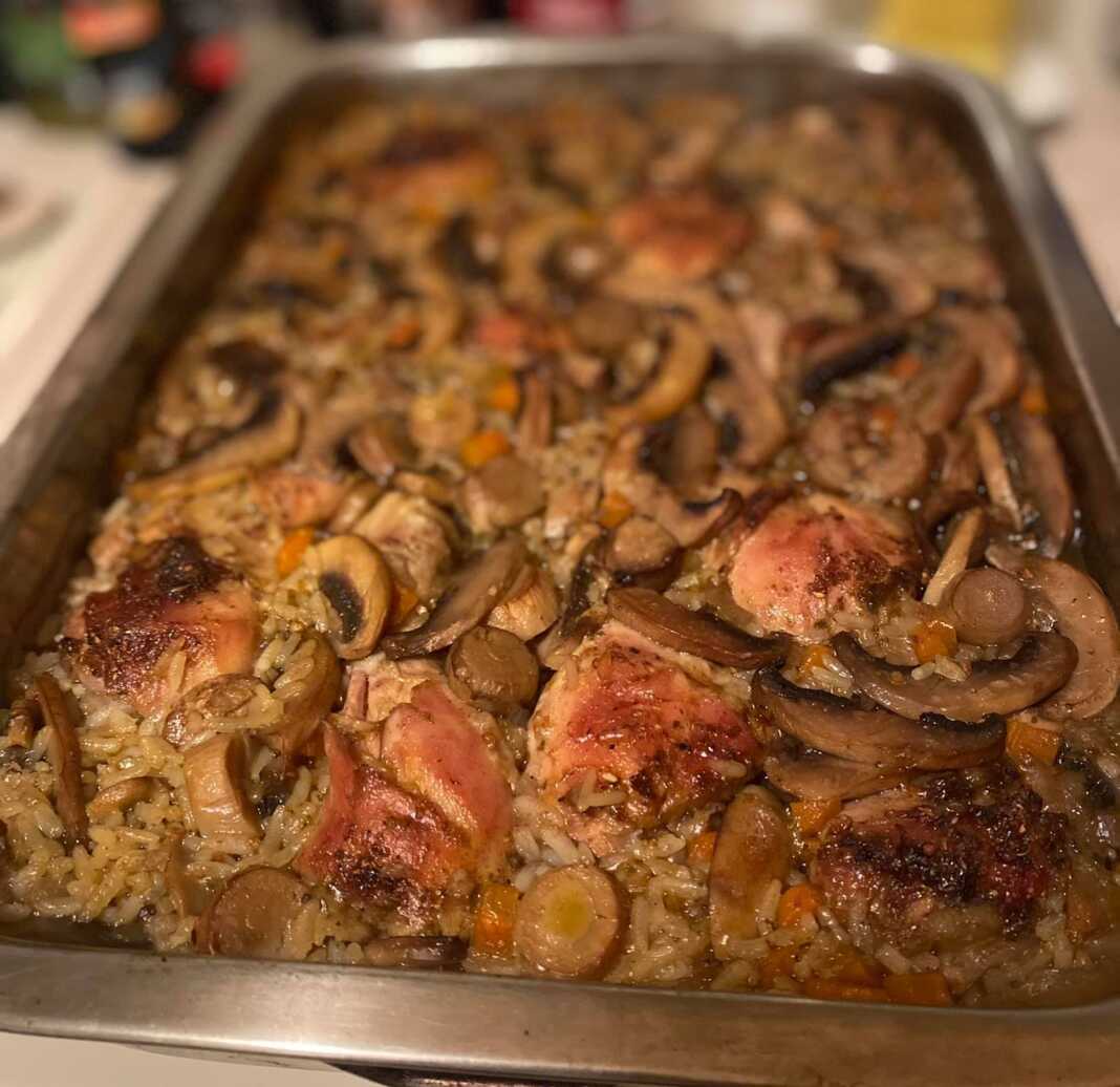 Ταψί με κοτόπουλο κομμάτια, ρύζι και μανιτάρια ψημένα στο φούρνο.