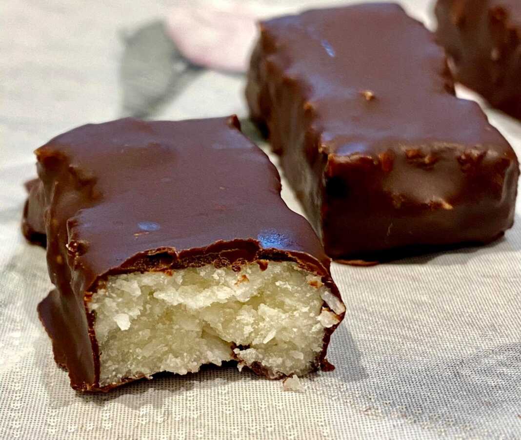 Παστάκια με καρύδα και μέλι, βουτηγμένα σε μαύρη σοκολάτα.