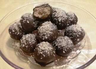 Σπιτικά τρουφάκια σοκολάτας καλυμμένα με γλάσο κουβερτούρας και πασπαλισμένα με τριμμένο αμύγδαλο πάνω σε αντικολλητικό χαρτί