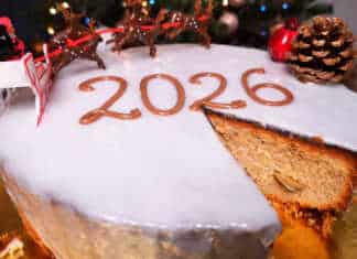 Μια εντυπωσιακή βασιλόπιτα κέικ καλυμμένη με λευκό γυαλιστερό γλάσο και στολισμένη για την υποδοχή του νέου έτους