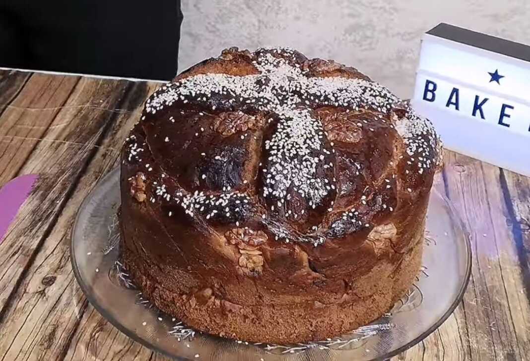 Αφράτο παραδοσιακό Χριστόψωμο με σταυρό από ζύμη, διακοσμημένο με καρύδια, αμύγδαλα και σουσάμι, έτοιμο για το γιορτινό τραπέζι.