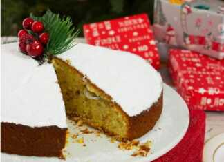 Βασιλόπιτα με χρυσαφένια κρούστα, πασπαλισμένη με ζάχαρη άχνη και διακοσμημένη με τα ψηφία του έτους, σερβιρισμένη σε πιατέλα