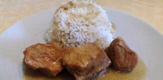 Ένα πιάτο με χοιρινό κομμένο σε μερίδες, περιχυμένο με λαδολέμονο και ρίγανη, δίπλα σε λευκό ρύζι μπασμάτι.