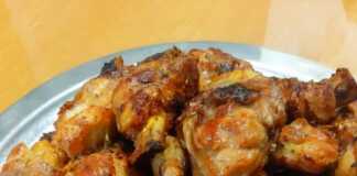 Ψημένα παϊδάκια κοτόπουλου με γυαλιστερή, καραμελωμένη σάλτσα, σερβιρισμένα σε πιάτο, με πιθανή γαρνιτούρα.