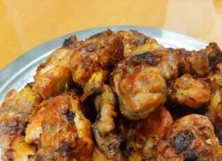 Ψημένα παϊδάκια κοτόπουλου με γυαλιστερή, καραμελωμένη σάλτσα, σερβιρισμένα σε πιάτο, με πιθανή γαρνιτούρα.