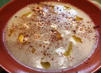 Ζεστή σούπα τραχανά σε βαθύ πιάτο με κυβάκια φέτας και πασπαλισμένη με κόκκινο πιπέρι καγιέν