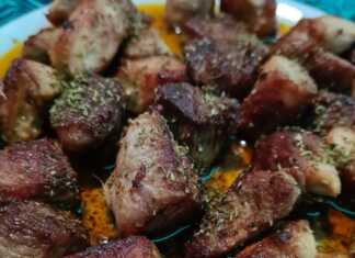 Καλοτηγανισμένα κομμάτια χοιρινού λαιμού μέσα στο τηγάνι με καραμελωμένα κρεμμύδια και φρέσκια ρίγανη