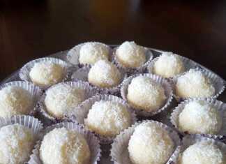 Ολόλευκα φοντάν καρύδας τοποθετημένα σε πιατέλα, καλυμμένα με τριμμένη καρύδα και στο εσωτερικό τους ένα ολόκληρο καβουρδισμένο αμύγδαλο.