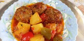 Ένα πιάτο με Κεφτεδάκια κοκκινιστά με πλιγούρι και πατάτες, περιχυμένα με πλούσια σάλτσα ντομάτας