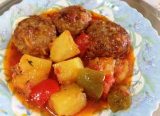 Ένα πιάτο με Κεφτεδάκια κοκκινιστά με πλιγούρι και πατάτες, περιχυμένα με πλούσια σάλτσα ντομάτας