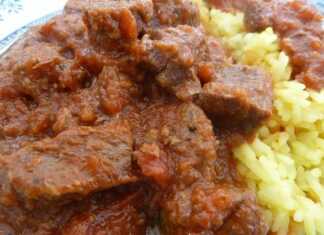 Ζουμερό μοσχαράκι κοκκινιστό με πηχτή κόκκινη σάλτσα σερβιρισμένο πάνω σε αχνιστό κίτρινο ρύζι