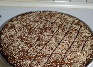 Παραδοσιακό λαδοραβανί Αμφιλοχίας στο ταψί, κομμένο σε ρόμβους, πασπαλισμένο με μπόλικο σουσάμι και ένα ολόκληρο αμύγδαλο στο κέντρο κάθε κομματιού.