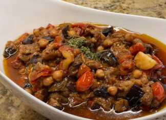 Παραδοσιακές Μελιτζάνες κοκκινιστές με ρεβύθια μέσα σε πήλινο σκεύος, γαρνιρισμένες με φρέσκο δυόσμο