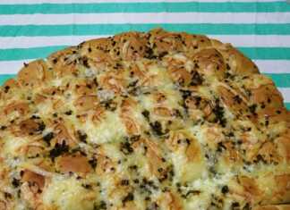 Ζεστό σκορδόψωμο κομμένο σε κύβους με λιωμένο τυρί και ψιλοκομμένο μαϊντανό στην επιφάνεια