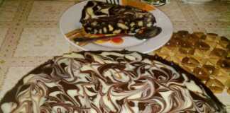 Ένα κομμένο κομμάτι μπισκοτογλυκού με στρώσεις μπισκότων, καρυδιών και σοκολάτας, καλυμμένο με λείο γλάσο σοκολάτας.