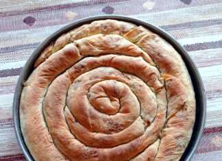 Κοτόπιτα με ρύζι σε σχήμα σαλιγκαριού, ψημένη, με χρυσαφένια κρούστα, έτοιμη για σερβίρισμα.