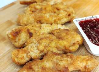 Τραγανές, χρυσαφένιες λωρίδες κοτόπουλου σαν KFC απλωμένες σε απορροφητικό χαρτί.