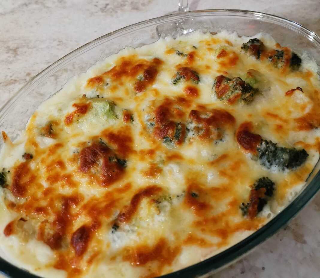 Ένα ταψί με ψημένο μπρόκολο καλυμμένο με χρυσαφένια σάλτσα μπεσαμέλ και λιωμένα τυριά.