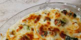 Ένα ταψί με ψημένο μπρόκολο καλυμμένο με χρυσαφένια σάλτσα μπεσαμέλ και λιωμένα τυριά.