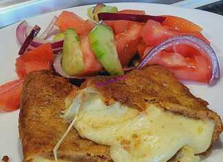 Τραγανά κομμάτια κίτρινου τυριού πανέ με χρυσή κρούστα σερβιρισμένα με φρέσκια σαλάτα αγγουροντομάτα