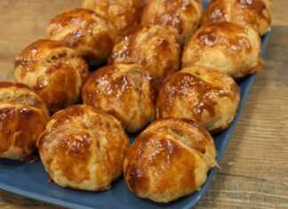 18 χρυσαφένιες μπάλες σφολιάτας, με σταυρωτή χάραξη στην κορυφή, τοποθετημένες σε ταψί, έτοιμες να σερβιριστούν.