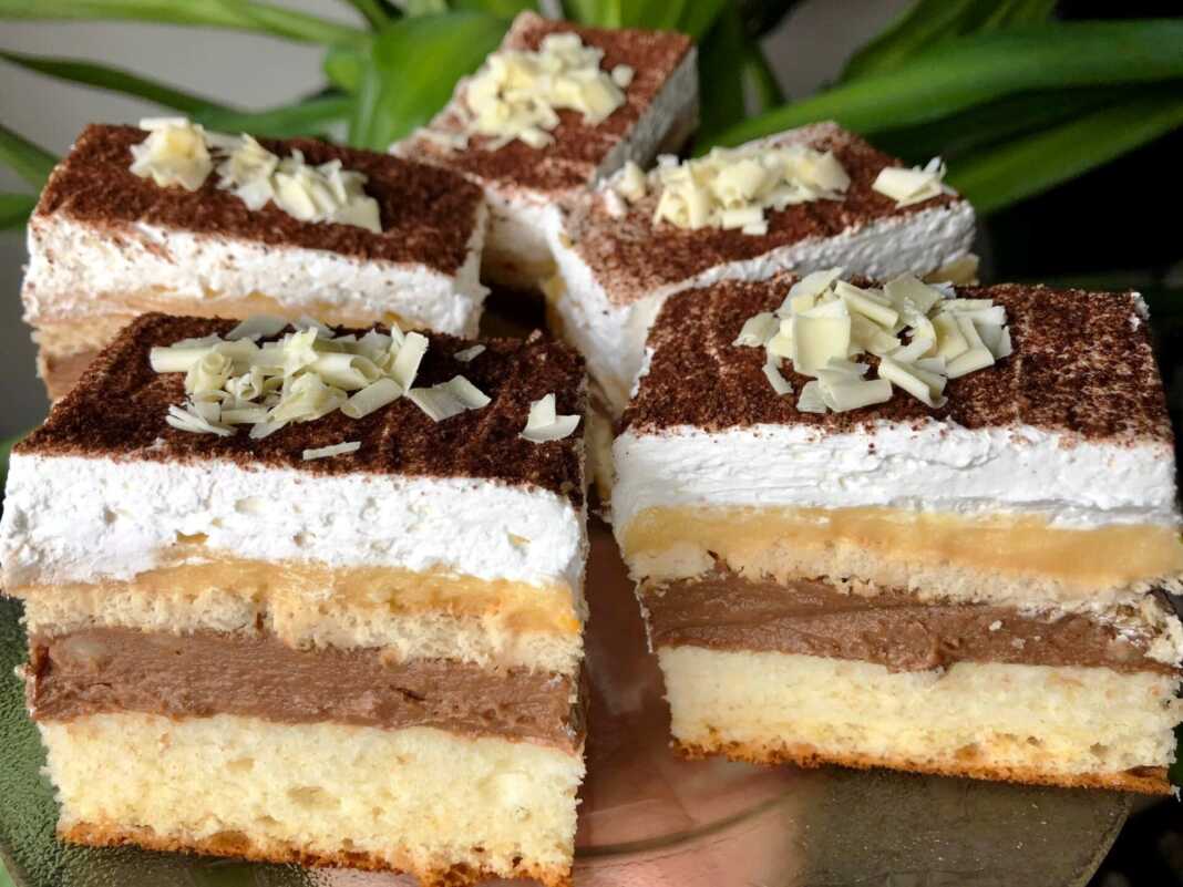 Μια φέτα από το κέικ με 2 κρέμες που φαίνονται οι στρώσεις βανίλιας, σοκολάτας και μπισκότων