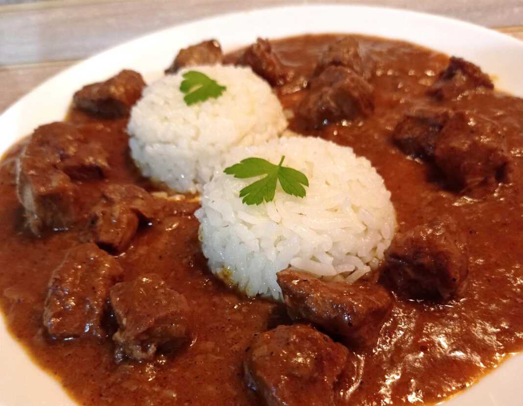 Πιάτο με Κεμπάπ κρασιού και ρύζι, γαρνιρισμένο με φρέσκο μαϊντανό.