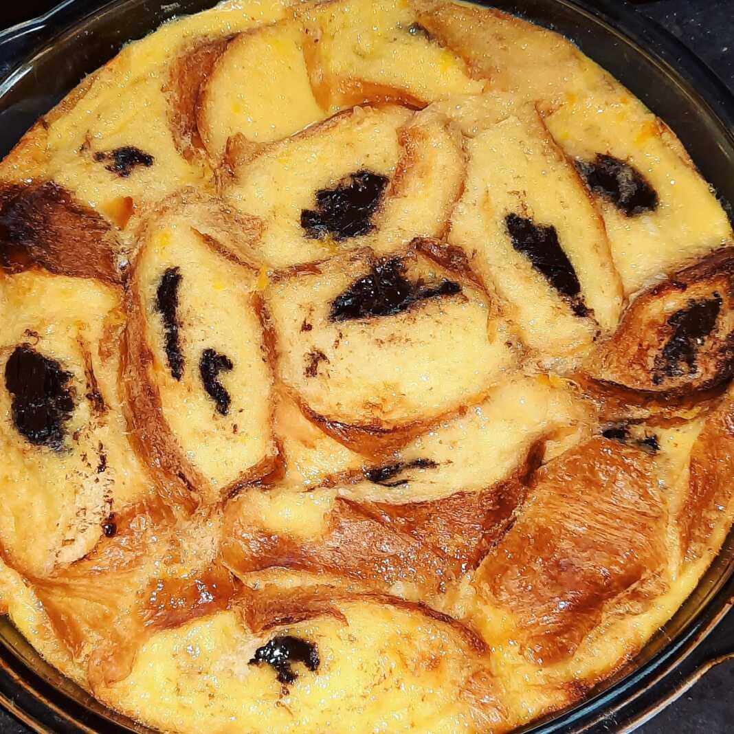 Κρέμα καραμέλας με στρώση από ροδέλες κρουασάν σοκολάτας σε ένα ταψί.