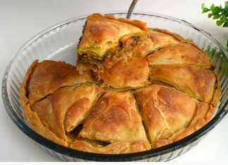 Μια χρυσαφένια μελιτζανόπιτα κομμένη σε κομμάτια, έτοιμη για σερβίρισμα.