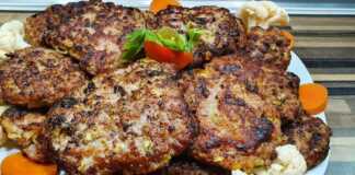 Τα ψημένα **Μπιφτέκια Φούρνου με Λαχανικά** σε πιάτο με συνοδευτικό