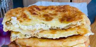 Τηγανητές πίτες διπλωμένες με τυρί και άνηθο, κομμένες στη μέση, με γέμιση να φαίνεται.