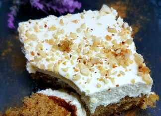 Κομμάτι καρυδόπιτας με στρώσεις λευκής κρέμας και σαντιγί πασπαλισμένο με τριμμένο καρύδι μέσα στο ταψί