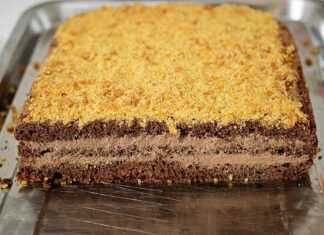 Πολυτελές κέικ σοκολάτας με στρώσεις κρέμας καλυμμένο με χρυσαφένια θρυμματισμένα καραμελωμένα αμύγδαλα