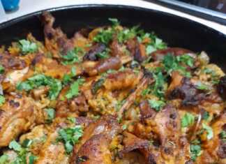 Ένα ταψί με ψητό κουνέλι πάνω από αφράτο ρύζι με μανιτάρια και κρεμμυδάκια.