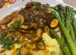 Ζουμερά Μπιφτέκια σε σάλτσα μανιταριών, σερβιρισμένα με πουρέ πατάτας και πράσινα σπαράγγια, πασπαλισμένα με μαϊντανό.