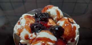 Ένα μπολ γεμάτο με κρεμώδες λευκό παγωτό γιαούρτι, με στροβιλισμούς από κόκκινο σιρόπι βύσσινο στην επιφάνεια.