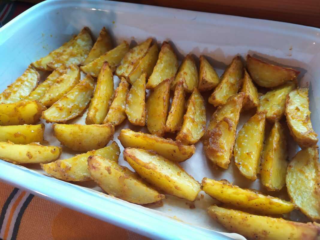 Κοντινό πλάνο σε πατάτες φούρνου με στεγνό κουρκούτι, που αναδεικνύει την χρυσαφένια και τραγανή κρούστα τους.