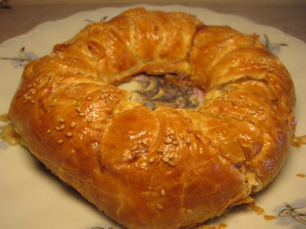 Χρυσαφένιο στεφάνι σφολιάτας γεμιστό με τυρί, ζαμπόν, αυγό και λαχανικά.